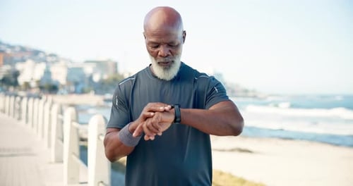 Senior Man Checks Watch on Beach Boardwalk