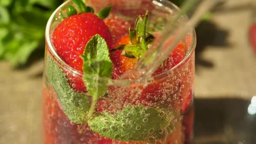 Refreshing Strawberry Drink with Mint Being Poured
