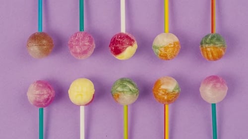 Süße Lutscher auf violettem Hintergrund, Zoom-Rahmen, helle Textur, Zuckerbonbons, Nahaufnahme von oben