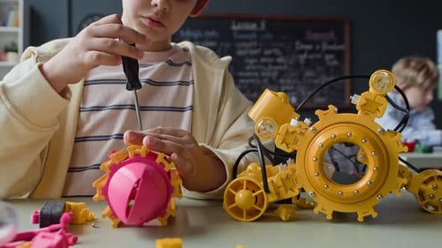 Junge baut Robotermodell mit Schraubenzieher in der Stem-Klasse zusammen