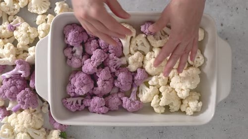 Cauliflower florets, white and purple, close-up in baking pan
