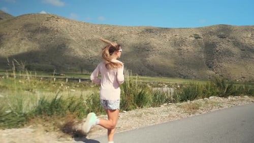 Athlete Runs a Road Beneath Stormy Mountains Preparing for Competition