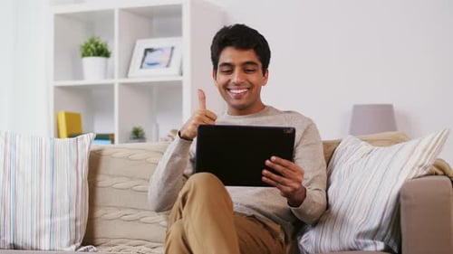 Man Relaxing on Sofa with Tablet Device