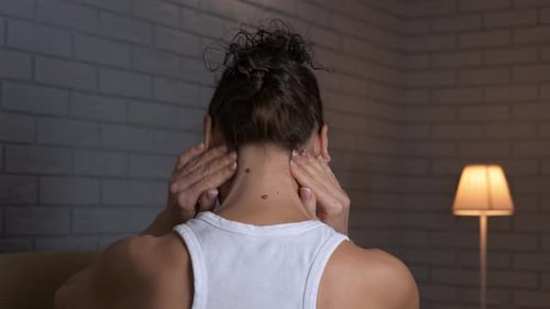 Frau leidet unter Nackenschmerzen und massiert ihre verspannten Muskeln