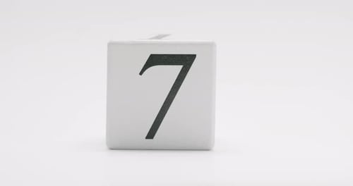 Minimalist Wooden Block with Number Seven on White Background