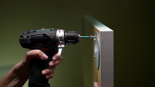 Power Drill Tightens Screw Into Cabinet Door
