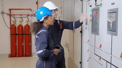Engineers Inspecting Industrial Control Panel