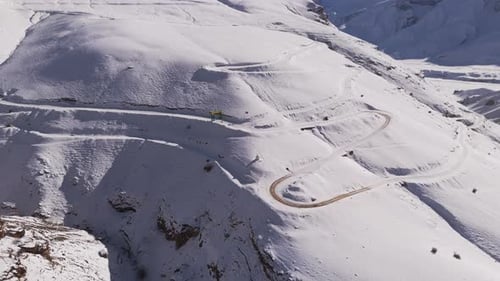 Aerial View of a Curving Mountain Road Cutting Through Snow-Covered Peaks spiti valley in Winter