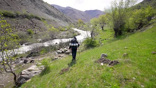 Lone Hiker Travels Through a Mountain Valley