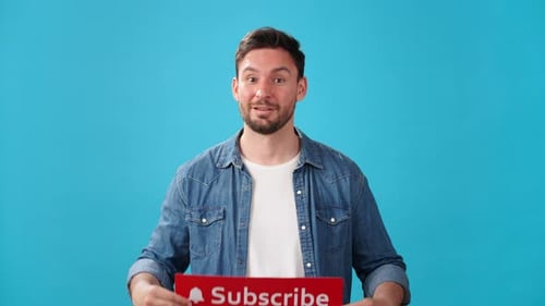Männlicher Blogger hält Schild mit Glocke und Aufschrift Abonnieren