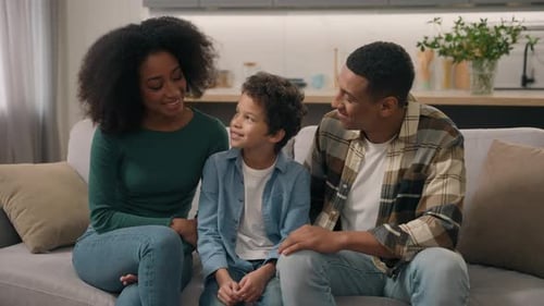 Happy Family Smiling Together on Couch in Home