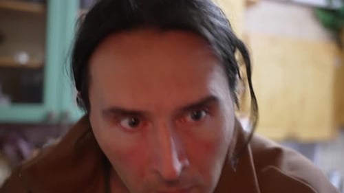 Man in Brown Jacket Picks Up Food