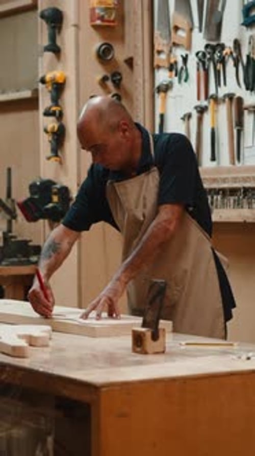 Professional Carpenter Marking Wood Plank with Pencil and Ruler in His Workshop