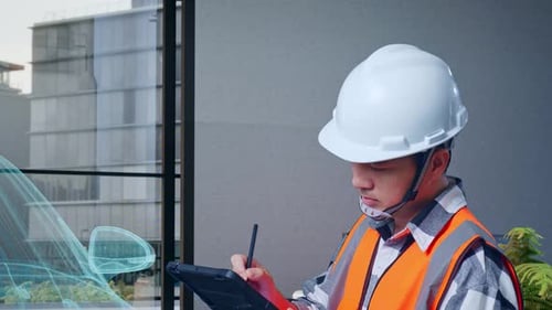 Engineer Using Tablet with Building Blueprint Overlay