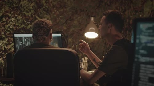 Two People Working on Computers in Camouflage Room