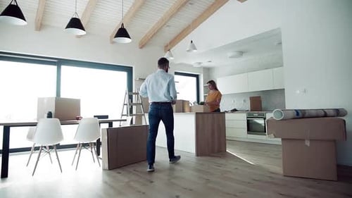 Couple moving into new modern house with boxes