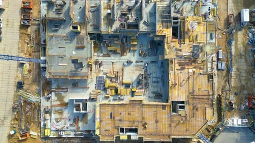 Aerial Flight Over a New Constructions Development Site with High Tower Cranes Building Real Estate.