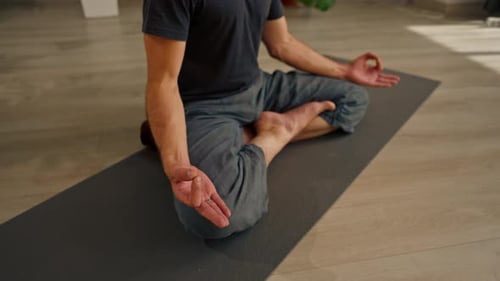 close-up of hands and fingers of man meditating in hall and sitting in lotus position man care
