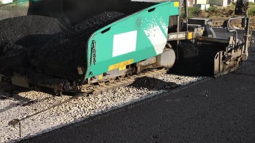 An Asphalt Spreader or an Asphalt Paver Machine on a Road Construction Site