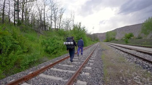 Traveler people walking along the railroad tracks