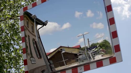 Kreative Reflexion einer Stadtszene im Straßenspiegel an einem sonnigen Tag