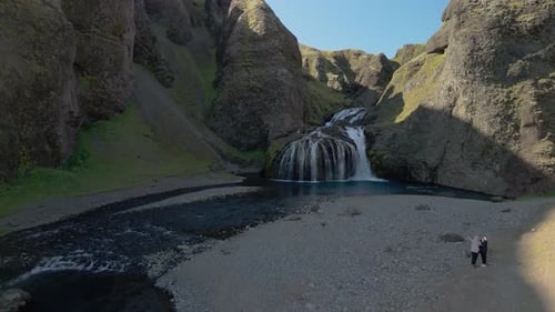 Majestic Waterfall Flowing Through Rocky Canyon Landscape