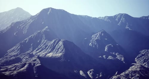 Chaîne de montagnes majestueuse sous un ciel clair capturée pendant la journée