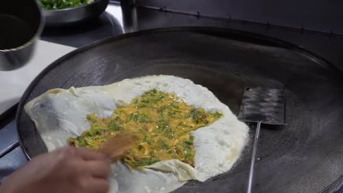 The process of making or cooking an Martabak Telur or Martabak Eggs, Indonesian street food.