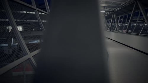 Man Leans Against Railing at Night Indoors