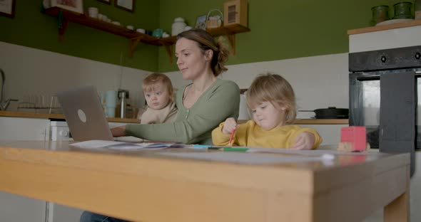 Mother multitasking with kids at home workspace, People Stock Footage ...
