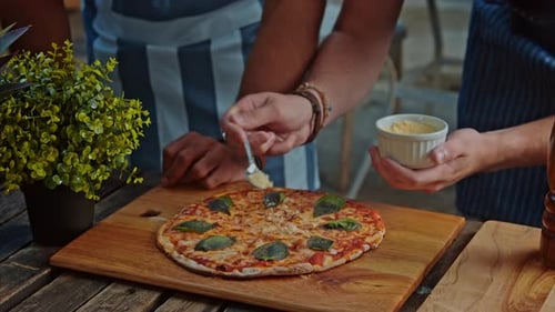 Delicious gourmet meal is given finishing touches by chefs at family pizza restaurant