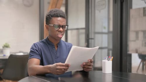 Frustrated Man Reading Documents in an Office