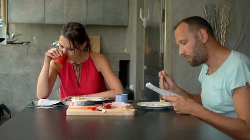 Couple Eats Breakfast While Reading News Indoors