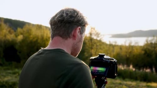 Photographer Using Camera in Field at Sunrise
