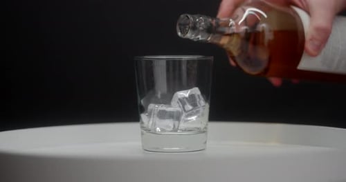 Whiskey Being Poured Into Glass With Ice