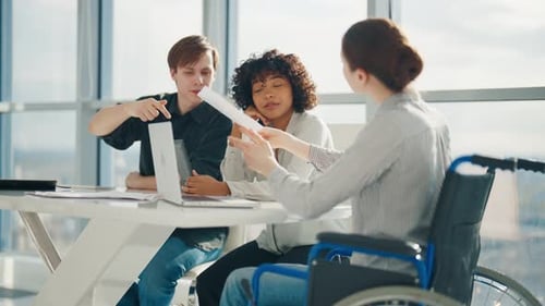 Friendly Colleagues Working on Project in Modern Office Together Sitting at Desk Woman in Wheelchair
