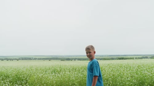 Young Boy Standing in Field of Flowers Smiling