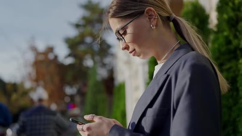 Young Professional Woman Using Smartphone on City Street