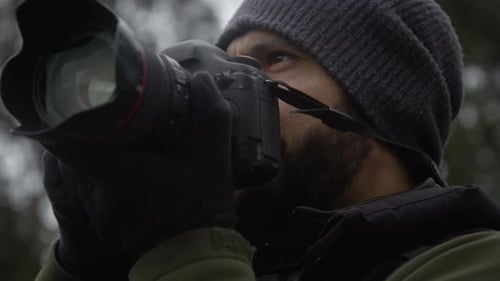 Man with beard taking photo in nature