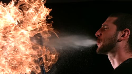 Man Firebreathing with Torch on Black Background