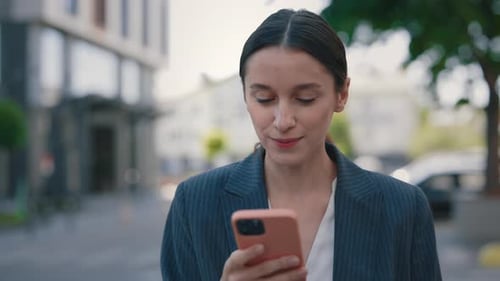 Attractive Businesswoman Using Mobile Phone App While Wallking in an Urban City Area Female Looking