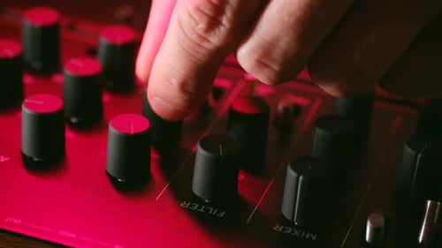Technician Turns Knobs on Console in Music Recording Studio