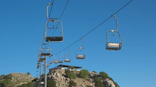 Ski Lift Above Rocky Mountain on Sunny Day