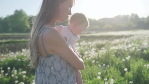 Family in the garden. Mother and baby walk in the countryside authentic garden during sunset