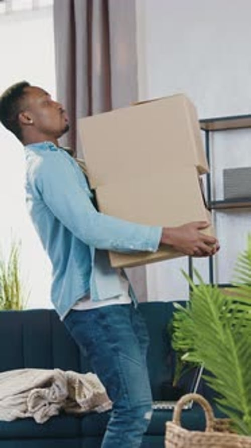 Lovely Satisfied Stylish Blackskinned Woman with Dreadlocks Drawing Up Cardboard Packings on Her