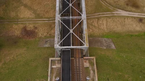 Vagões cheios de carvão se movendo por ponte ferroviária com trem