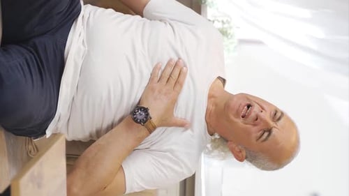 Senior Man Experiencing Chest Pain on Couch