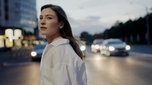 Mujer elegante en escena nocturna de la ciudad con semáforos borrosos