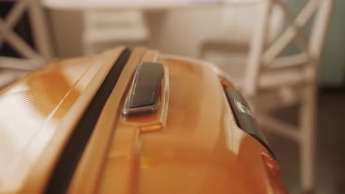 Hand Pushes Up Handle of Suitcase Closeup