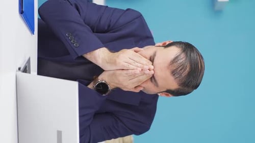 Man with Hands on Face in Workplace